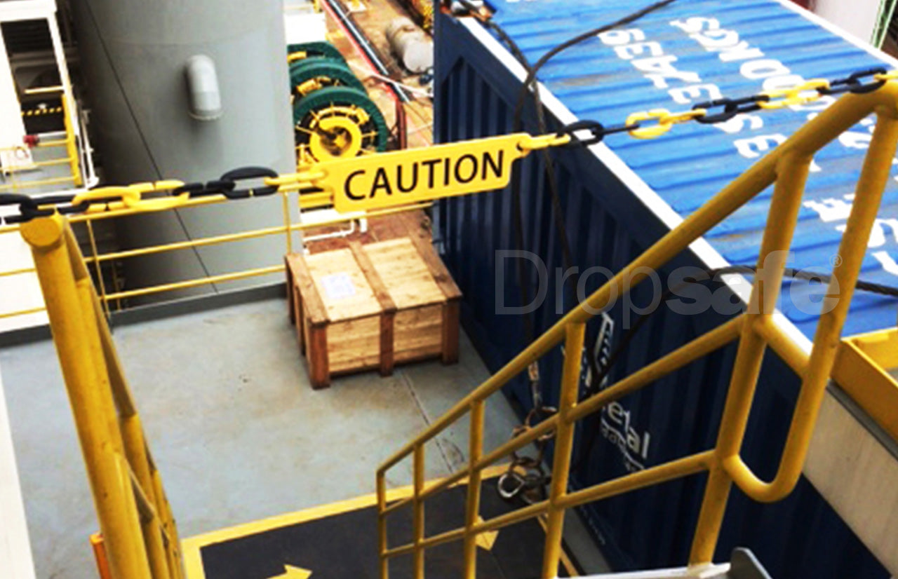 Yellow and black plastic chain link barricade, with CAUTION sign, blocking the entry to a stairwell.