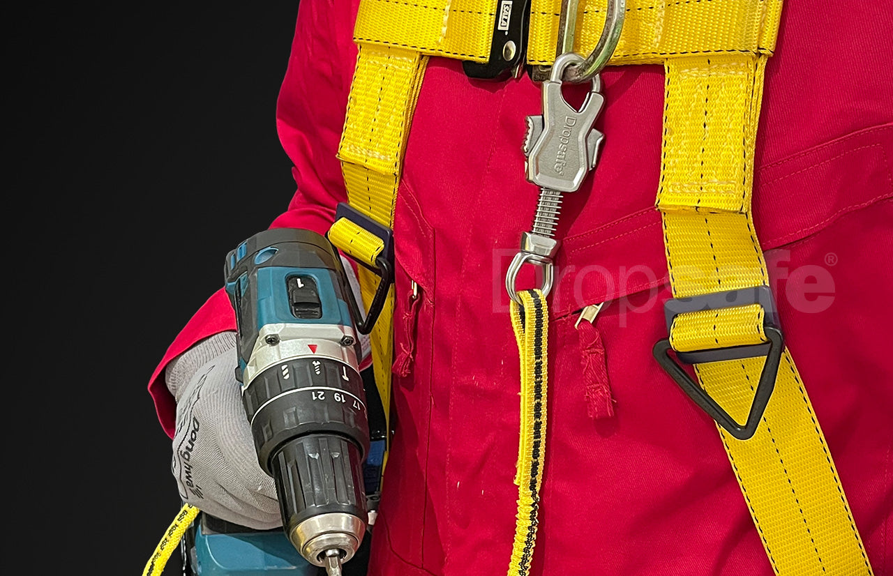 Blue and black cordless drill in work glove with bungee tool lanyard twin carabiners