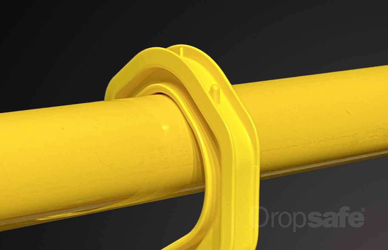 Bright yellow plastic pipe clamp securing cylindrical tube, small cable hook