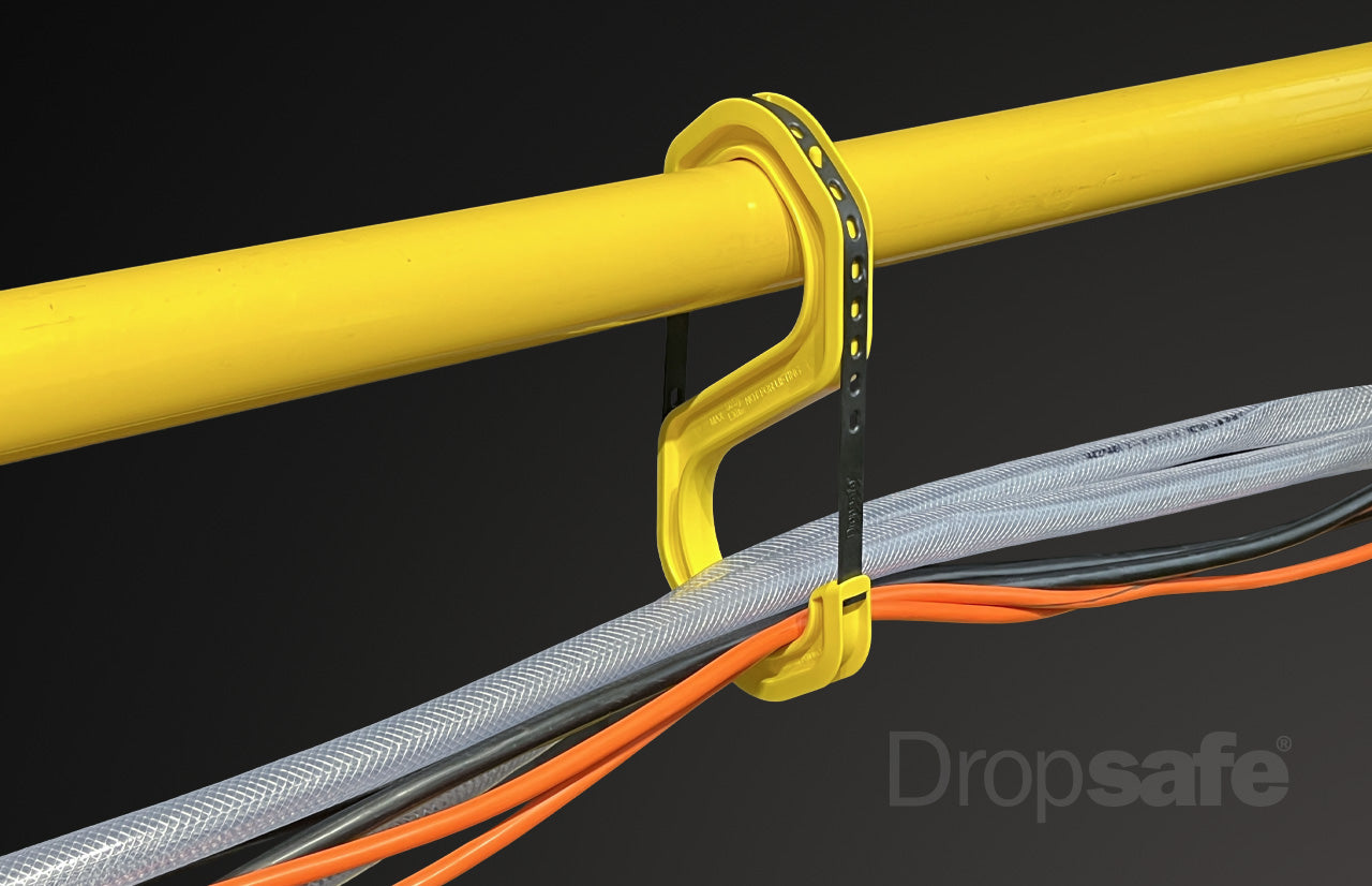 Yellow plastic cable tie securing gray, black, orange cables to yellow pipe