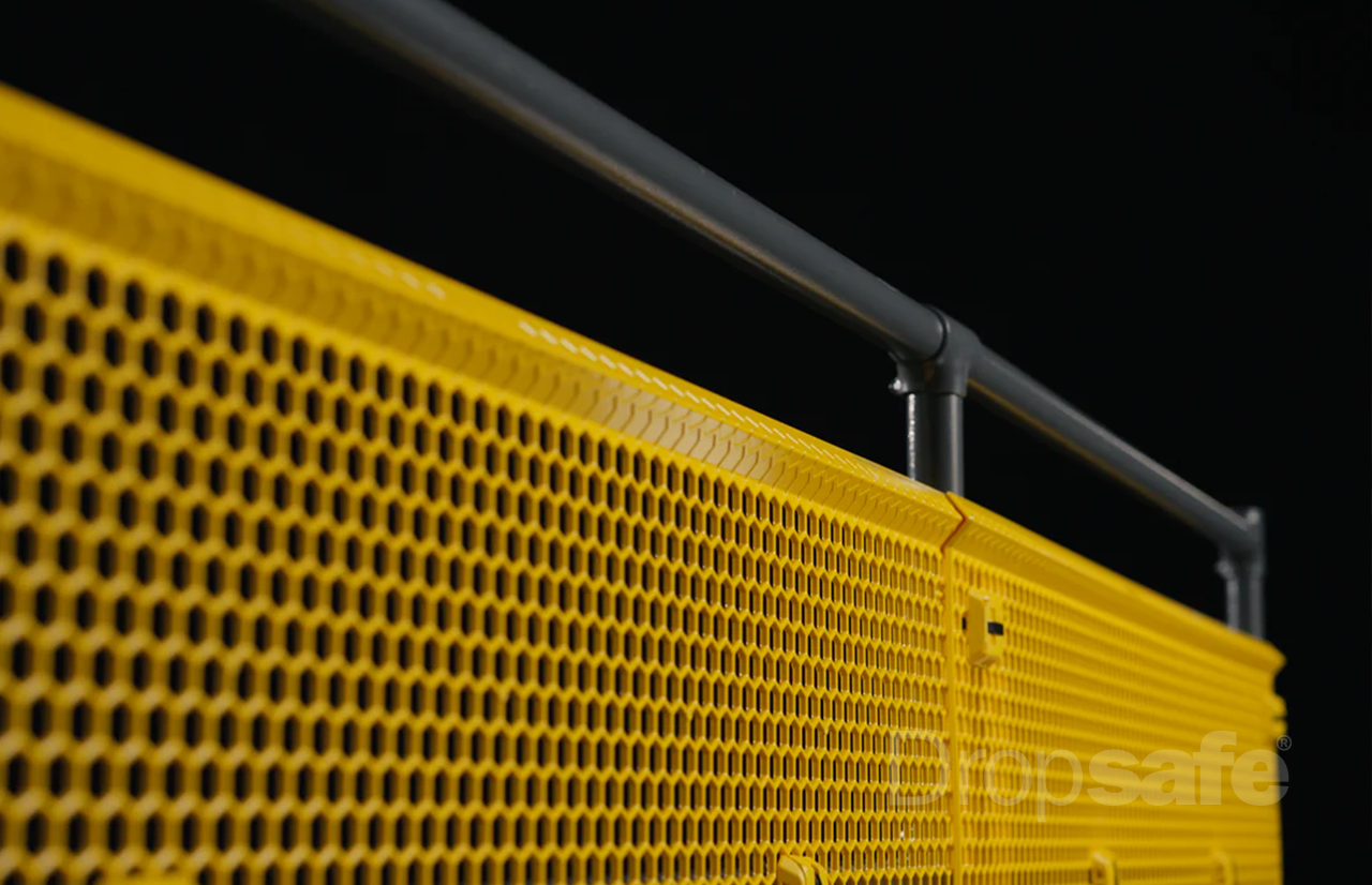 Bright yellow hexagonal mesh Dropsafe Barrier with black metal rail