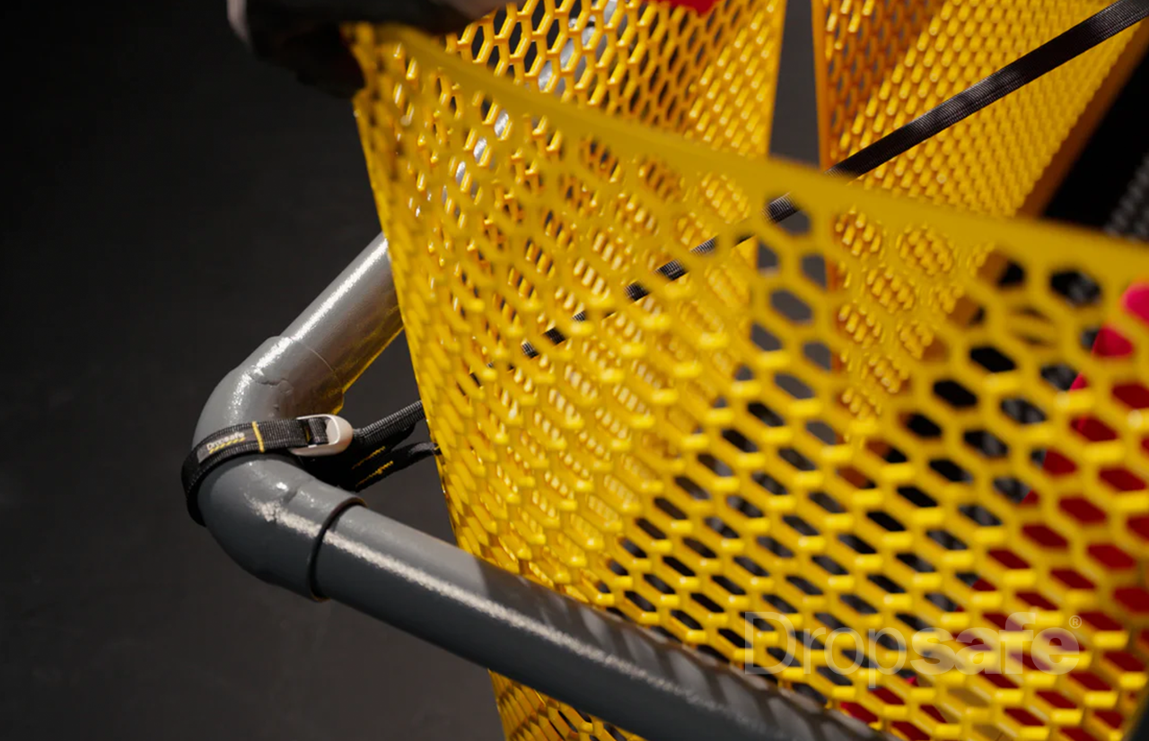 Bright yellow perforated mesh basket on gray metal frame with black straps, Dropsafe Barrier