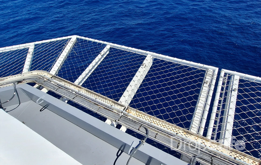 Dropsafe Helideck white metal safety railing with diamond mesh over blue ocean