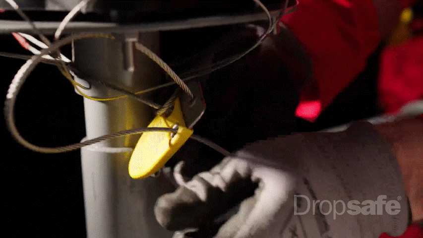 Yellow plastic safety lock securing steel cable to metal pole in Dropsafe Nets