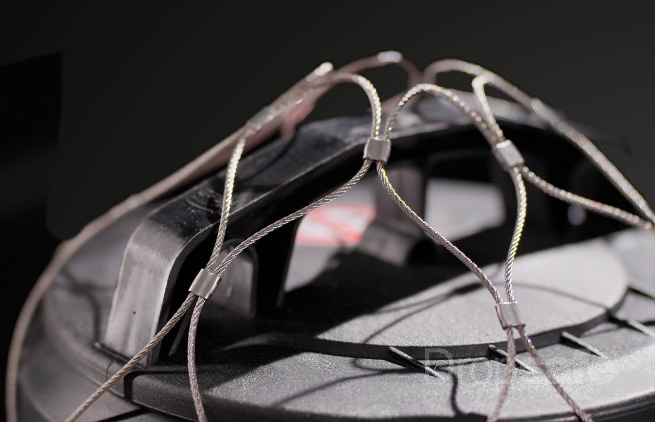 Silver steel cable netting with Trisafe carabiner securing black helmet